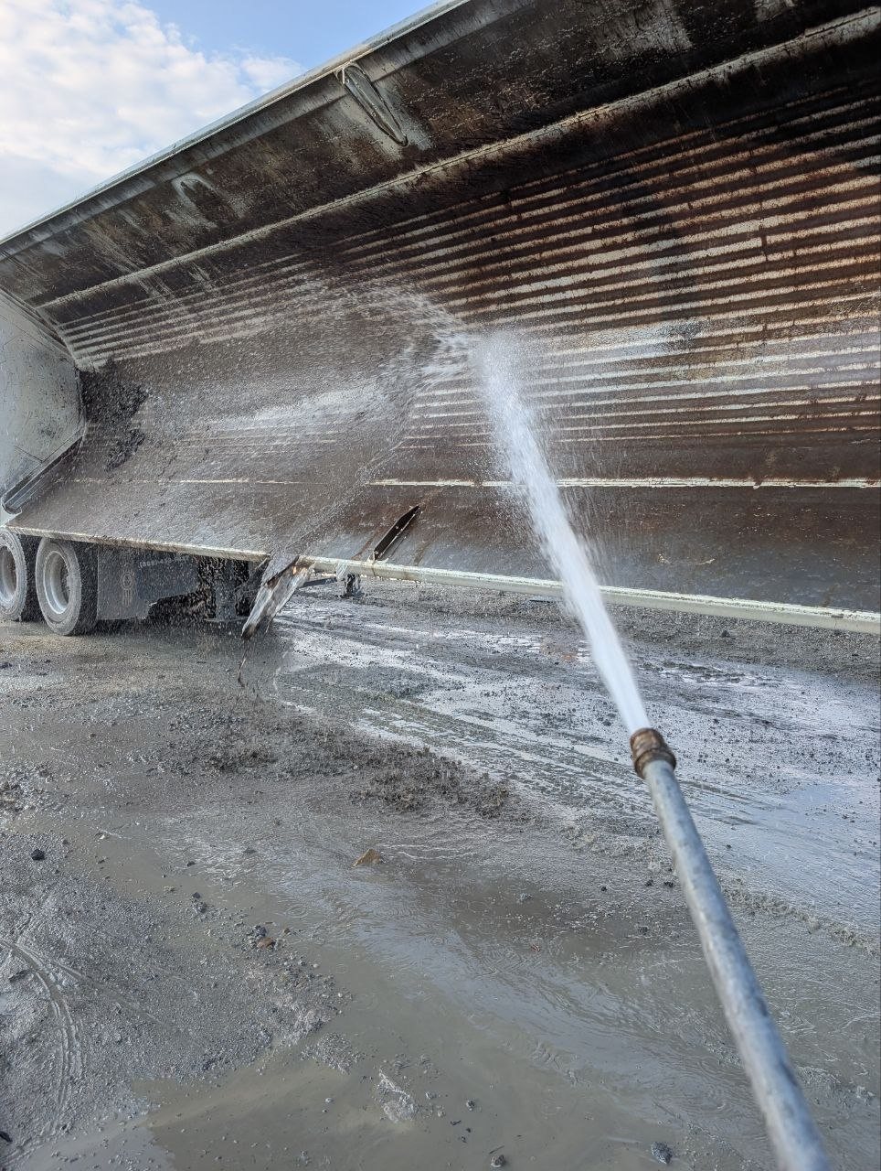 Cleaning a side dump trailer tub before hauling clean import material
