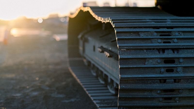 Heavy equipment excavator tracks at sunset on a Utah construction site