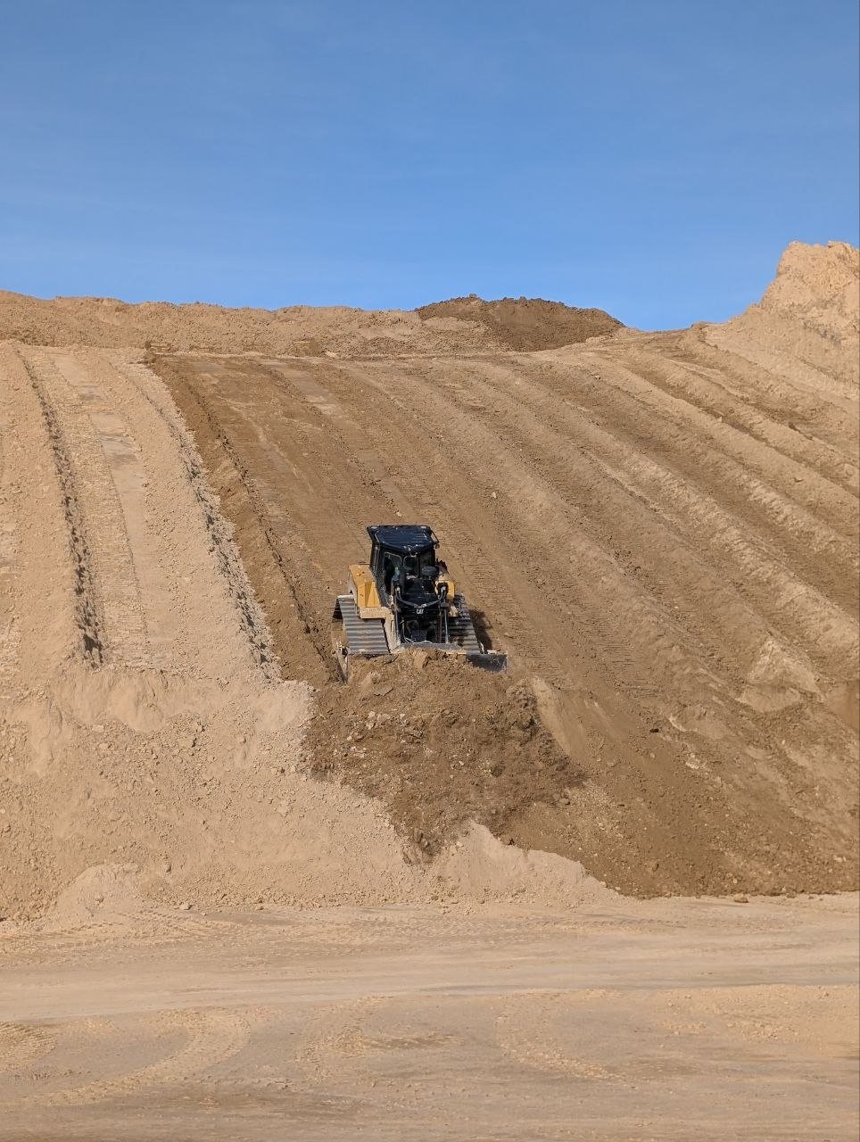 Dozer moving filter press sand at a Utah aggregate source before delivery